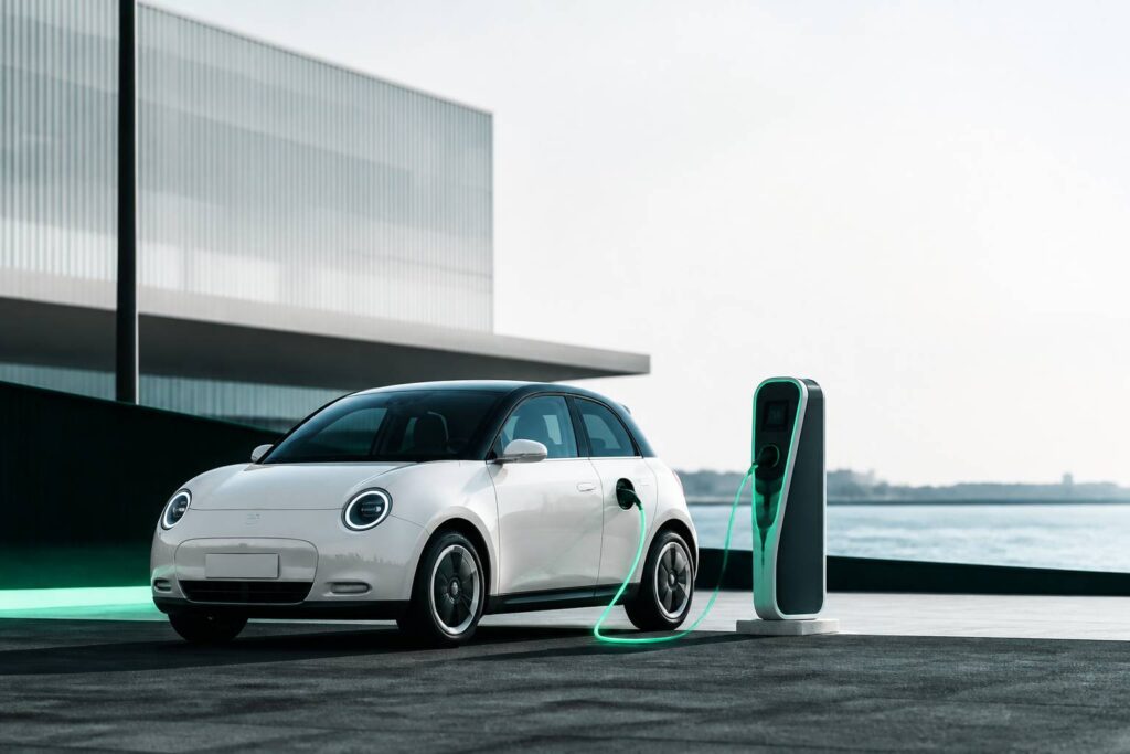 Citadine électrique compacte près d'une borne de recharge
