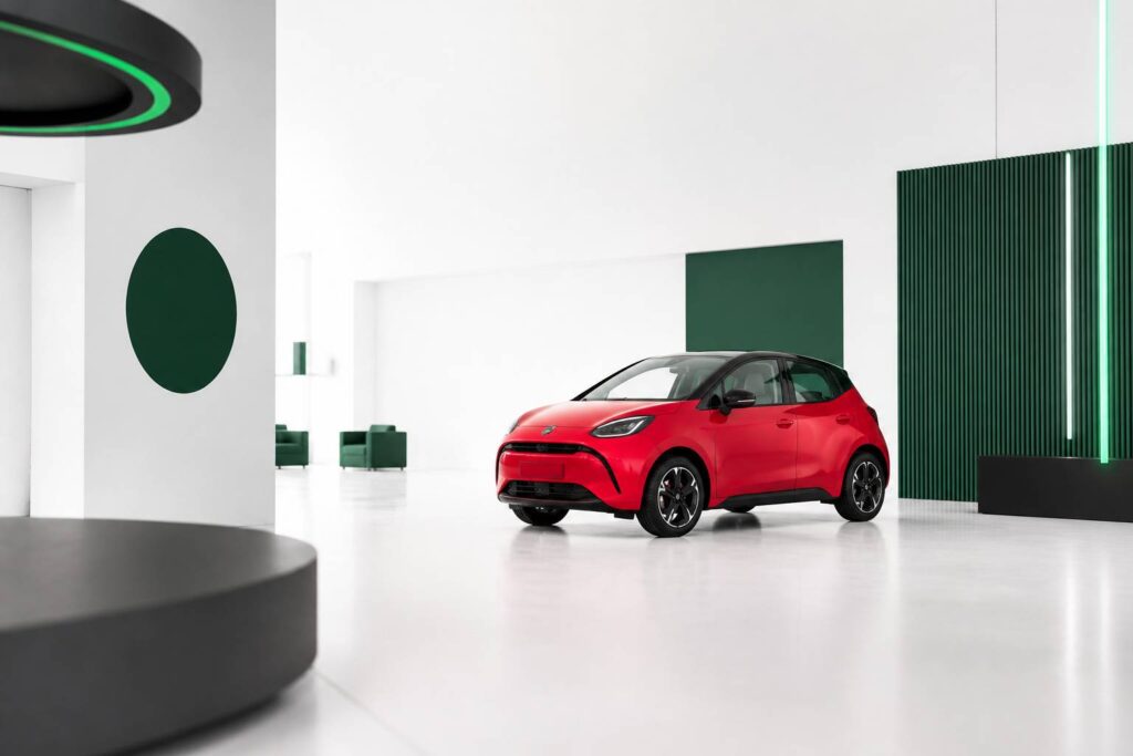 Petite voiture électrique rouge dans un showroom clair et aéré