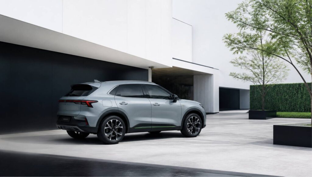 SUV hybride compact gris clair garé devant un bâtiment épuré aux lignes nettes