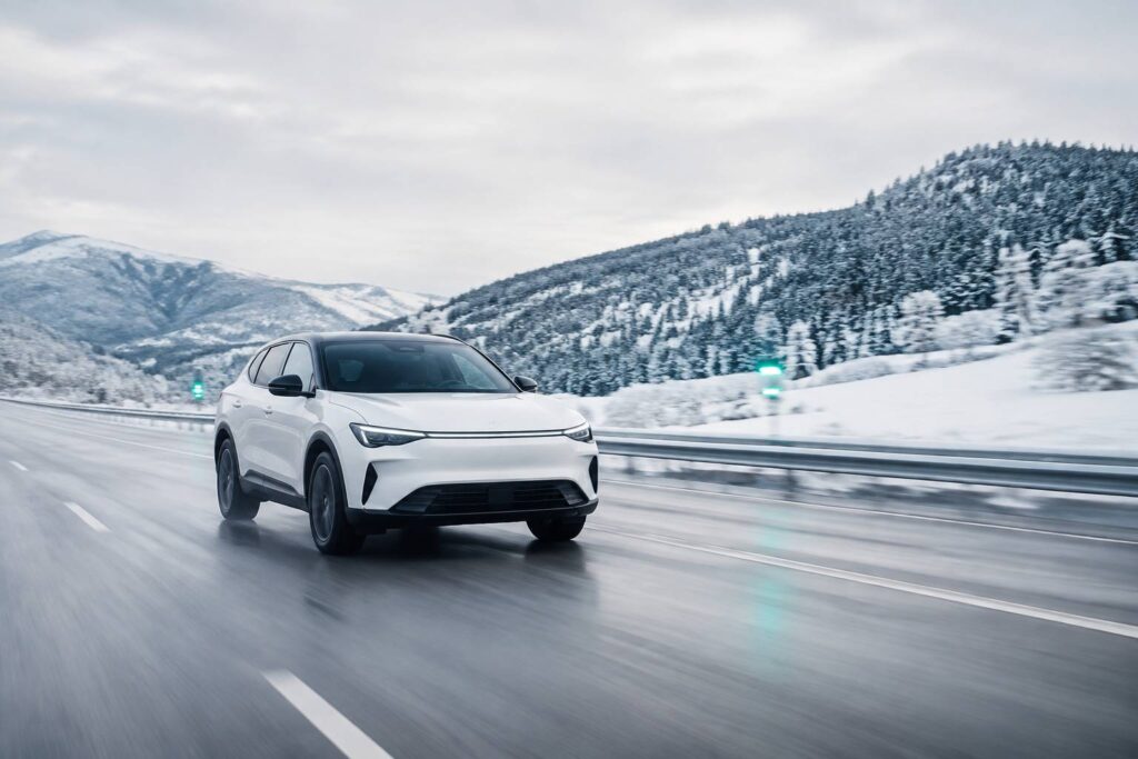 SUV électrique blanc générique sans badge sur une autoroute hivernale dégagée